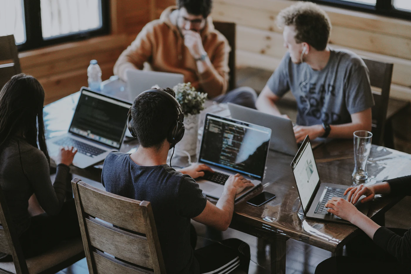 Equipo de trabajo analizando información técnica en una mesa con computadoras portátiles